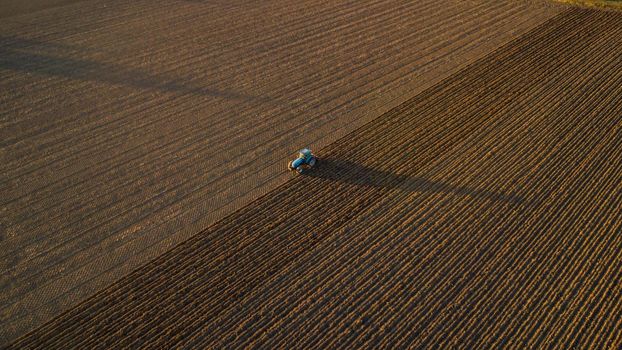 farmer with tractor leveling land in the countryside.