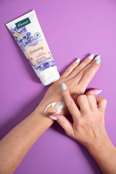 douche exfoliante Kneipp cosmetics, Lavender and jojoba,woman testing shower scrub on handAs,Belgium, June 30,2022, High quality photo