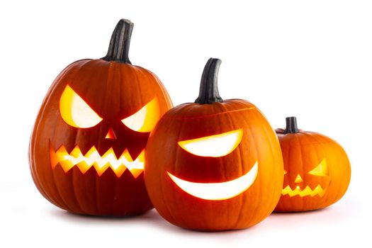 Three Halloween glowing funny lantern pumpkins isolated on white background