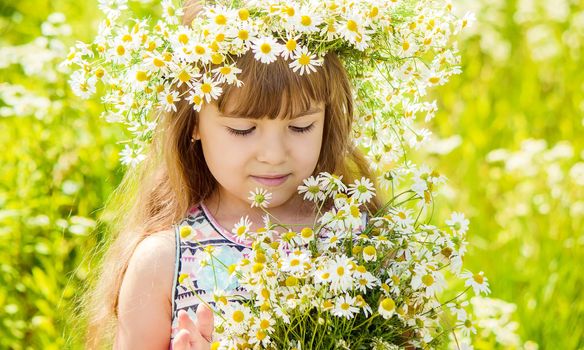 Girl with chamomile. Selective focus. nature flowers. Child.