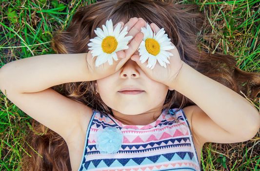 Girl with chamomile. Selective focus. nature flowers. Child.