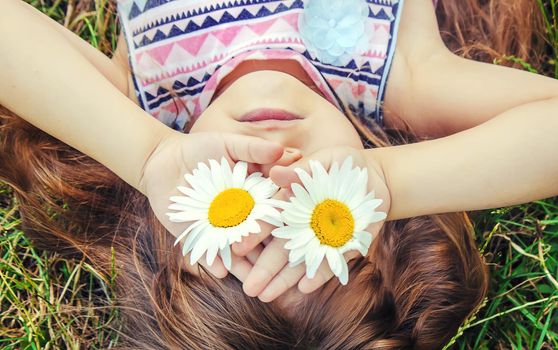 Girl with chamomile. Selective focus. nature flowers. Child.