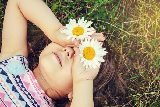 Girl with chamomile. Selective focus. nature flowers. Child.