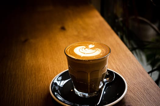 A cup of coffee latte top view with leaf shape foam