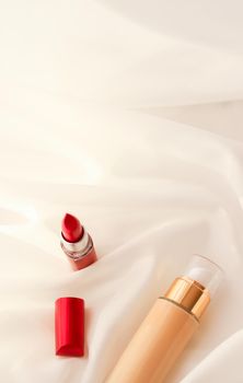 Cosmetic branding, glamour and skincare concept - Beige tonal cream bottle make-up fluid foundation base and red lipstick on silk background, cosmetics products as luxury beauty brand holiday design