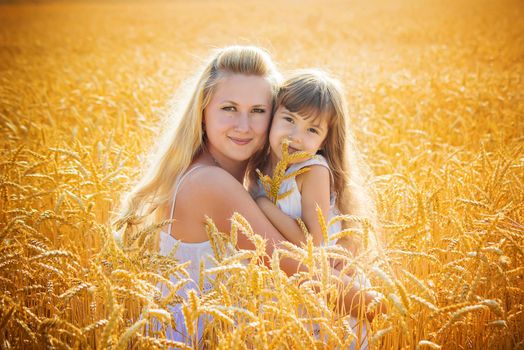 mother and daughter in a wheat field. selective focus. Nature.