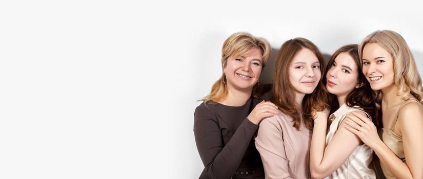 Happy Family of Mother with Three Daughters on Light Grey Background. Fashion Style Studio Portrait. Beautiful Women wearring Femininity Beige Dresses. Mothers Day, Womens Day or March 8 Style