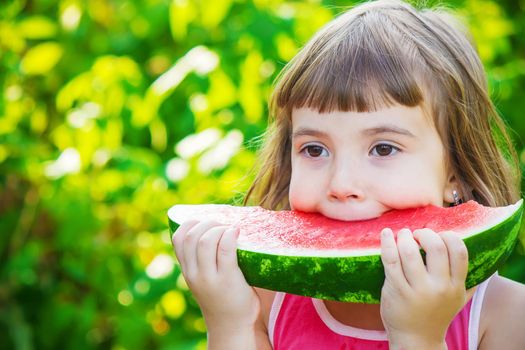 A child eats watermelon. Selective focus. Food nature.