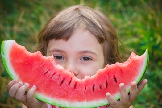 A child eats watermelon. Selective focus. Food nature.