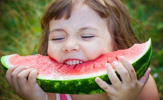 A child eats watermelon. Selective focus. Food nature.