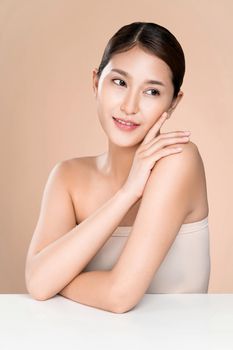 Portrait of ardent young woman with healthy clear skin and soft makeup looking at camera and posing beauty gesture. Cosmetology skincare and beauty concept.