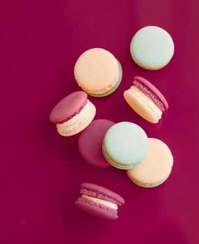 Pastry, bakery and branding concept - French macaroons on cherry pink background, parisian chic cafe dessert, sweet food and cake macaron for luxury confectionery brand, holiday backdrop design
