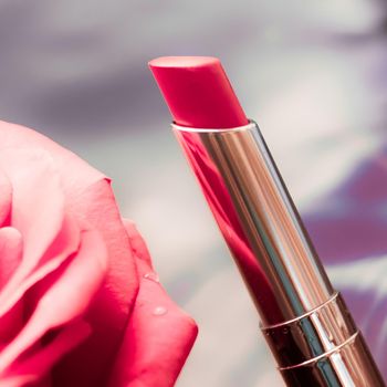 Cosmetic branding, luxe and fashion concept - Pink lipstick and rose flower on liquid background, waterproof glamour make-up and lip gloss cosmetics product for luxury beauty brand holiday design