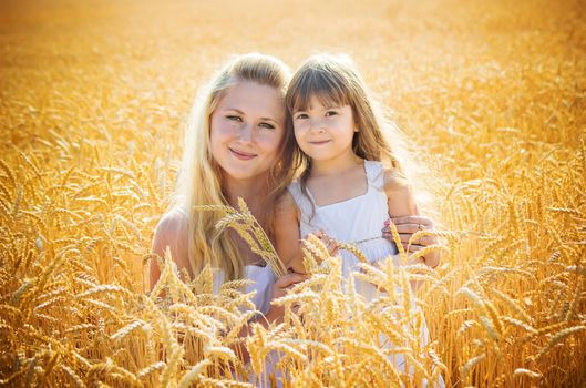 mother and daughter in a wheat field. selective focus. Nature.
