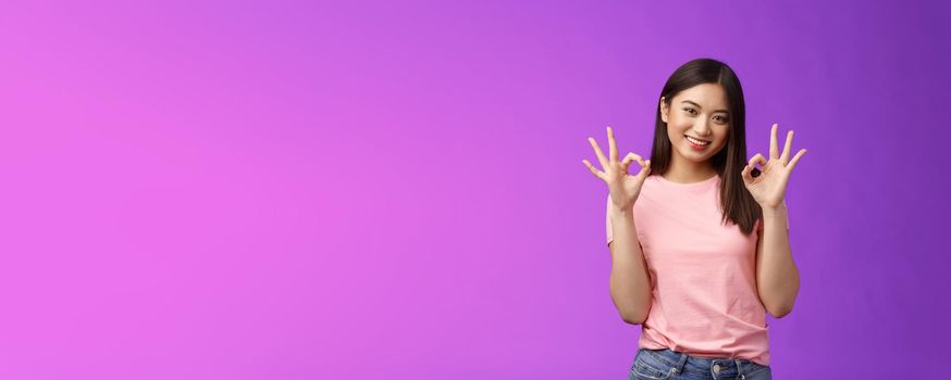 Friendly joyful good-looking stylish asian girl brunette show okay accept sign, smiling delighted feel fine, give recommendation, approve nice choice, stand purple background satisfied.