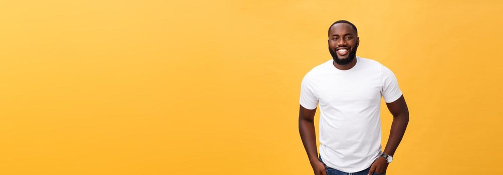 Portrait of delighted African American male with positive smile, white perfect teeth, looks happily at camera, being successful enterpreneur, wears white t shirt