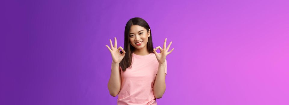 Friendly joyful good-looking stylish asian girl brunette show okay accept sign, smiling delighted feel fine, give recommendation, approve nice choice, stand purple background satisfied.