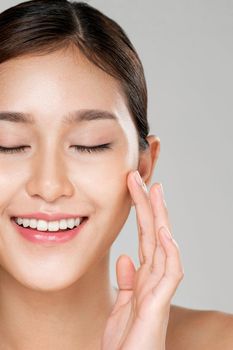 Closeup ardent young woman with healthy clear skin and soft makeup looking at camera and posing beauty gesture. Cosmetology skincare and beauty concept.