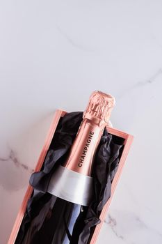 Celebration, drink and branding concept - Champagne bottle and gift box on marble, New Years, Christmas, Valentines Day or wedding holiday present and luxury product packaging for beverage brand