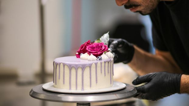 chef usign macaron , flowers and text sign for a celebration cake