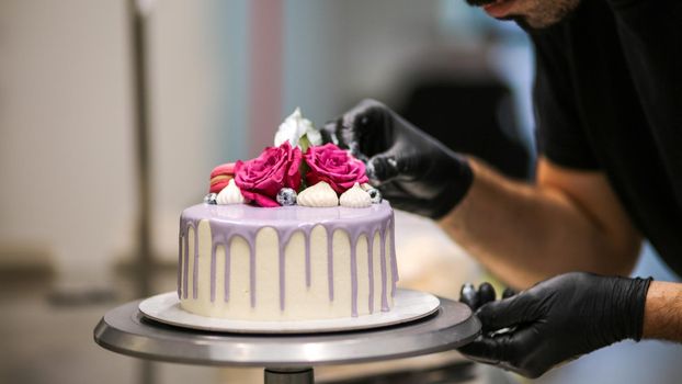 chef usign macaron , flowers and text sign for a celebration cake