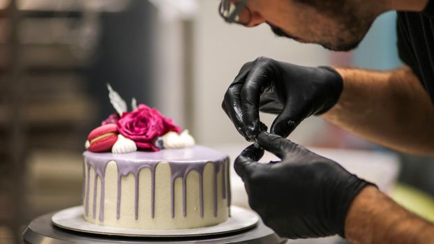 chef usign macaron , flowers and text sign for a celebration cake