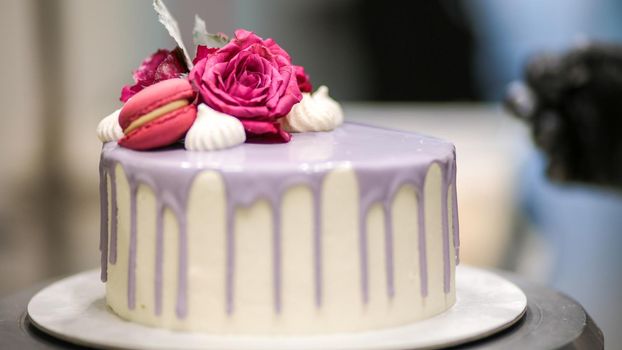chef usign macaron , flowers and text sign for a celebration cake