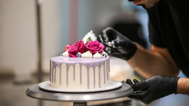 chef usign macaron , flowers and text sign for a celebration cake