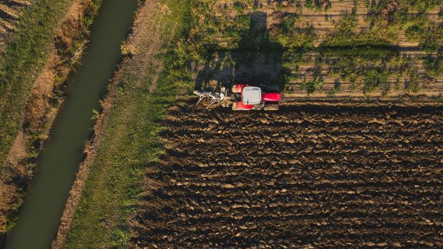 Aerial view with drone of tractor plowing the land in the countryside.