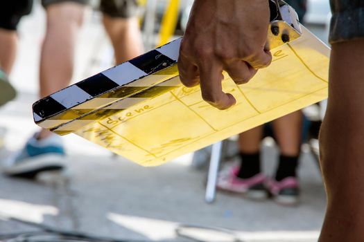 close up image of film production crew holding Film Slate on set