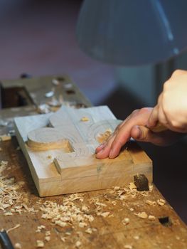 Close up of professional master artisan luthier painstaking detailed work on wood violin in a workshop.