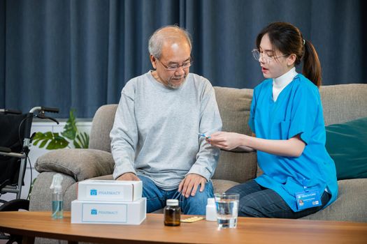 Asian doctor with physician visit senior male patient consult medicine dosage at house in living room, Woman nurse caregiver showing prescription drug to senior man at nursing home, healthcare support