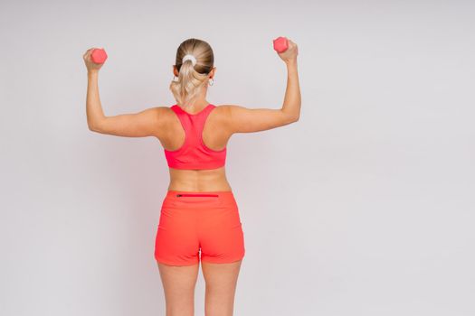 Full length portrait of smiling young woman in a sportswear isolated over studio background.