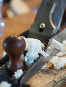 Close up of professional master artisan luthier painstaking detailed work on wood violin in a workshop.