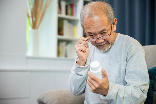 Asian old man buy herbal self cure Rx pill online from pharmacy, worried senior man with medicine pills he read on see how to take pills before taking, home isolation, Medical service concept