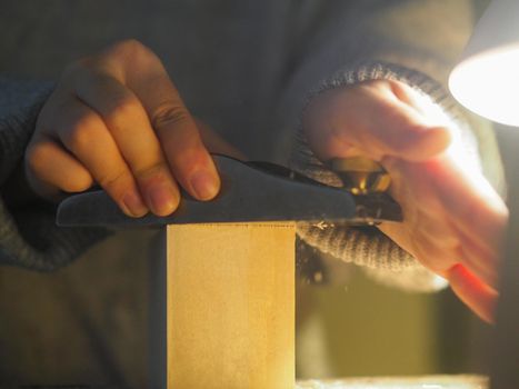 Close up of professional master artisan luthier painstaking detailed work on wood violin in a workshop.