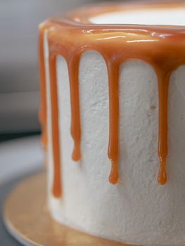 professional baker decorating a chocolate and cream cake with salty caramel