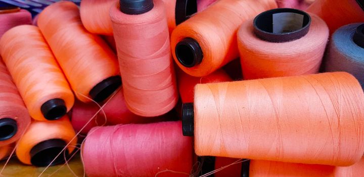 Colorful yarn on spool, yarn on tube, cotton, wool, linen thread orange