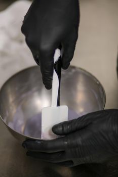 chef making for icing a lilac drip cake in the professional kitchen lab