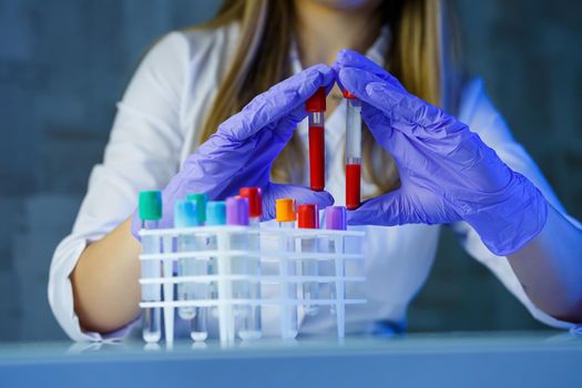 A medical professional, laboratory assistant, doctor performs an analysis in a laboratory, uses test tubes, a pipette and a petri dish for the presence of bacteria in the human body