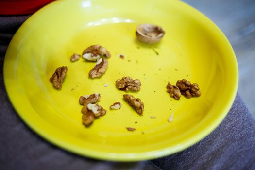 The girl peels the walnuts from the shell.