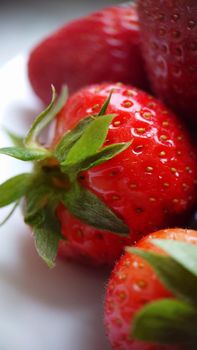 Texture or background.Ripe red strawberries on a white plate.Macrophotography