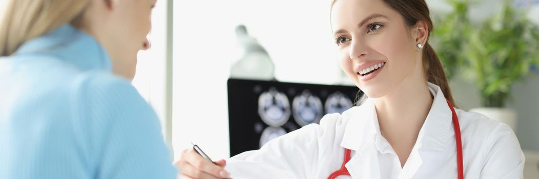 Portrait of woman doctor explain x ray ultrasound result to lady patient. Planned appointment in luxury clinic center. Gynecology, medicine, health concept