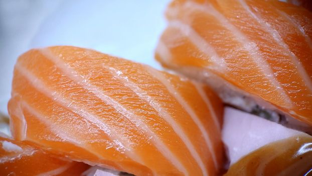 Traditional sushi rolls of Japanese cuisine from red fish.View from above.Texture or background.Macrophotography