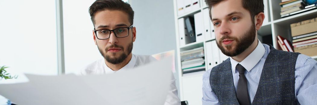 Portrait of group of people hold financial papers, solve and discuss problem. Male team in office, work on creative project. Chaos, mess, business concept