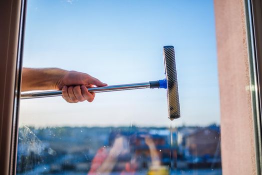 Window cleaning in high-rise buildings, houses with a brush. Window cleaning brush. Large window in a multi-storey building, cleaning service. Dust removal and glass washing.