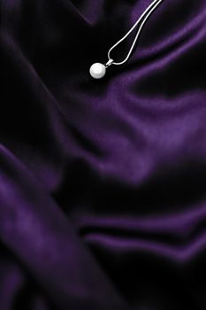 Jewellery brand, elegant fashion and bridal luxe gift concept - Luxury white gold pearl necklace on dark violet silk background, holiday glamour jewelery present