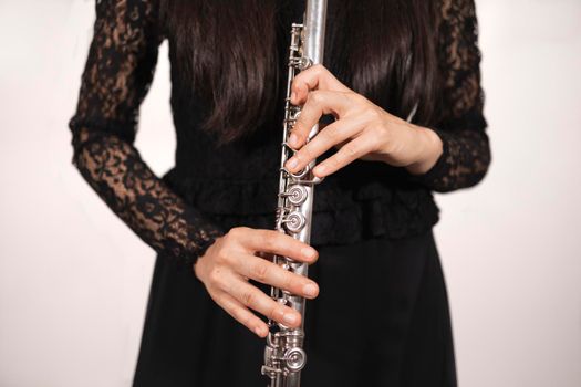 Close up of the hands of a female flutist while using the correct technice while holding her instrument