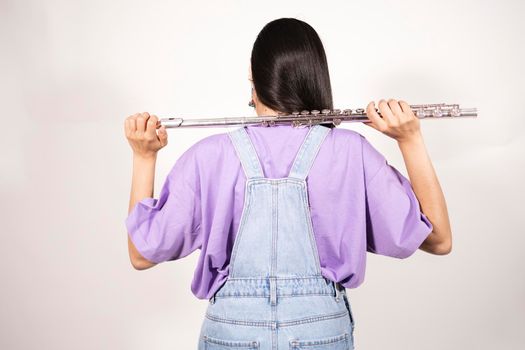 Back view of a young female flutist holding her instrument over her shoulders