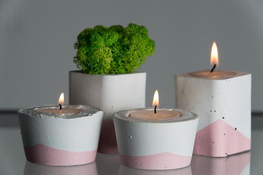 candles and moss in white and pink concrete candle holders.